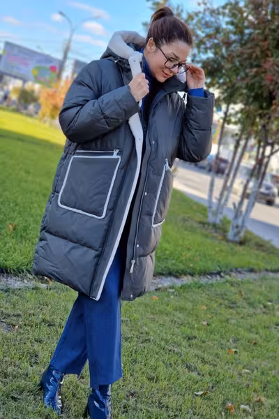 Пуховик средней длины с капюшоном и мехом серый зимний