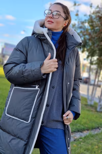 Пуховик средней длины с капюшоном и мехом серый зимний